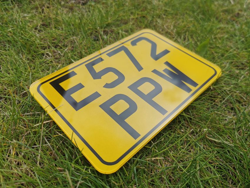 small printed 6x4 motorcycle numberplate with a yellow background and a black border.