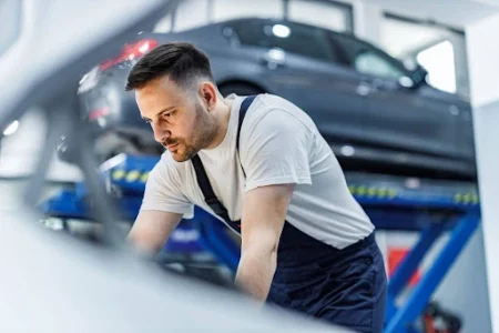 Mechanic carrying out an MOT in a workshop, illustrating the process involved