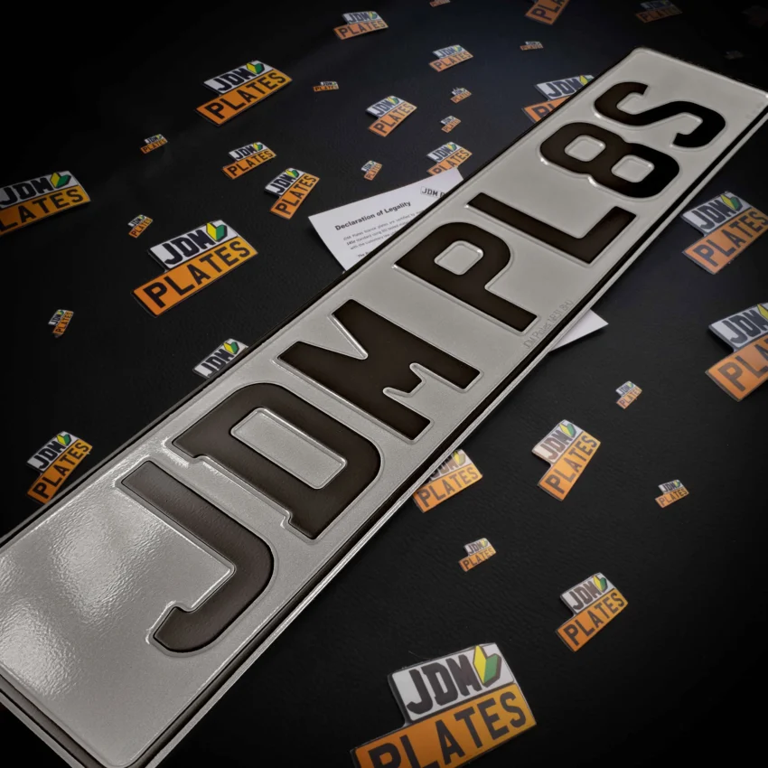 Front pressed metal number plate showcasing the registration number 'JDM PL8S'.