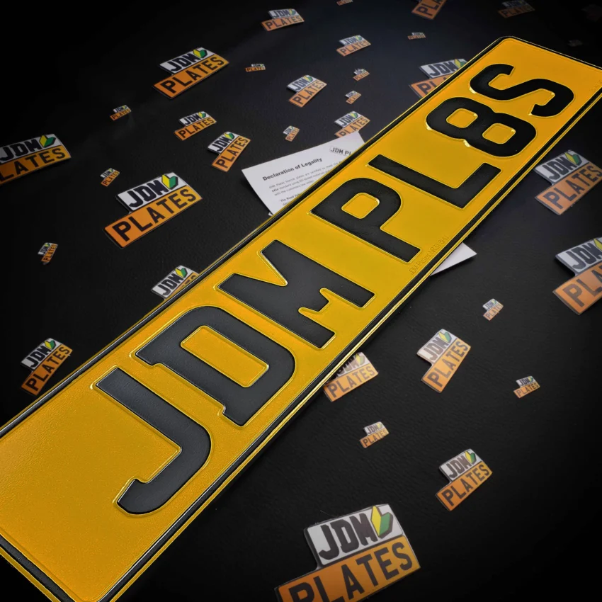 Rear pressed metal number plate showcasing the registration number 'JDM PL8S'.