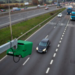 Vehicles on motorway in sight of ANPR camera surveillance, highlighting legal compliance.