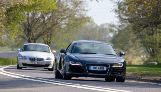 Two performance cars driving on a UK road, both displaying private registration plates that are fully road legal and compliant with DVLA standards.