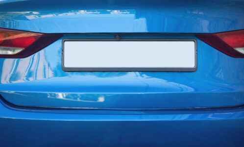 Rear view of a blue vehicle with a number plate designed in a ghost plate style, showing reflectivity suitable for Automatic Number Plate Recognition (ANPR) systems. 
