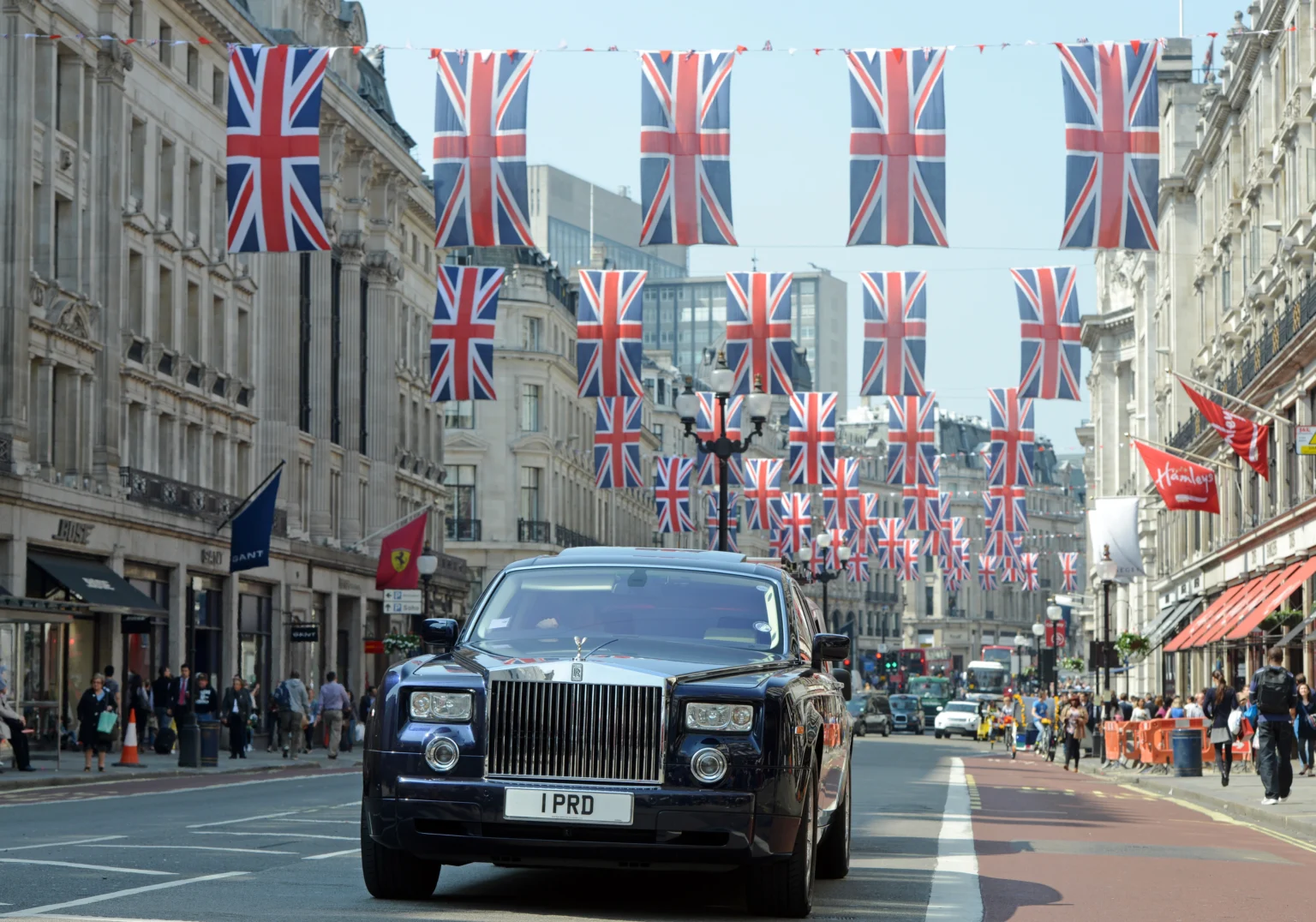 Rolls-Royce Phantom with personalised number plate “1 PRD” driving down Regent Street, London, under Union Jack flags